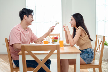 Couple Enjoys a Cheerful Breakfast at a Bright, Modern Dining Table in a Cozy Home Setting