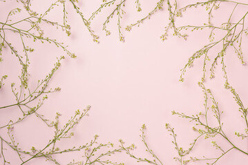 Frame of flowers on pink background. Flat lay, top view. Copy space
