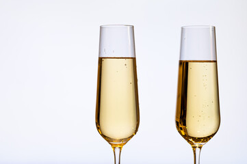 A minimalistic image featuring two champagne glasses filled with golden sparkling wine, set against a plain white background. The composition conveys elegance and a celebratory mood.