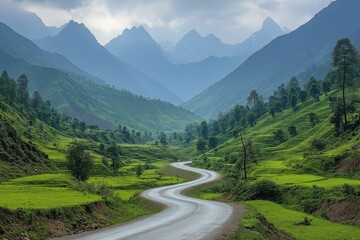 Fototapeta premium Scenic winding road through lush green hills with distant mountains under cloudy sky
