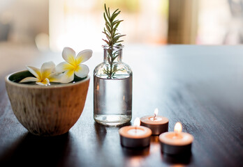 Flowers, rosemary and water in spa for self care, wellness and natural treatment with candles. Salon aesthetic, holistic and herbs for cosmetics, aromatherapy and beauty for zen, calm and peace