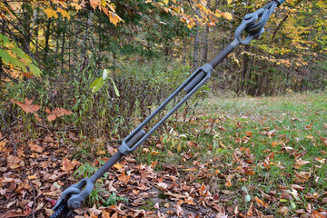 Galvanized steel turnbuckle with jaw ends under tension. Adjustable length steel cable fitting