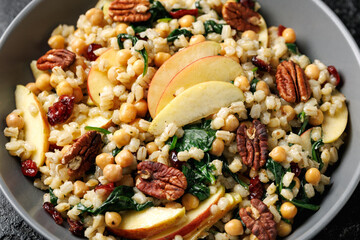 Warm barley pearl salad with kale, dried cranberries, apples and roasted pecan nuts. Healthy food