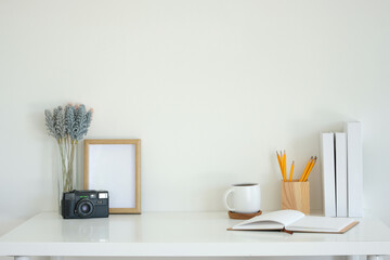 Simple workspace retro camera and lavender flowers, notebook, coffee mug and writing supplies.
