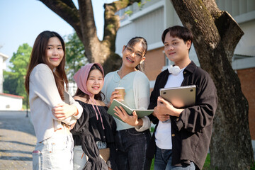 Cheerful University students sharing knowledge and ideas outdoors on campus. Education concept.