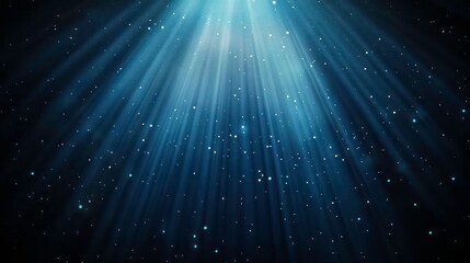 Bright blue light rays shining down on dark background with sparkles.