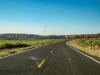 A long, empty road with a clear blue sky above