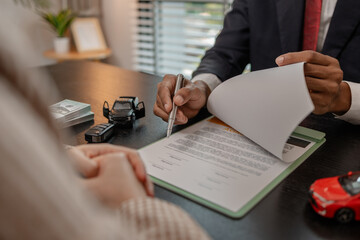 a car salesperson is explaining the details of a car purchase contract to the buyer before signing the sales contract, showroom, dealer, car contract, sining a car purchase contract
