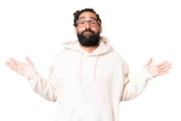 Young man with beard over isolated chroma key background having doubts while raising hands
