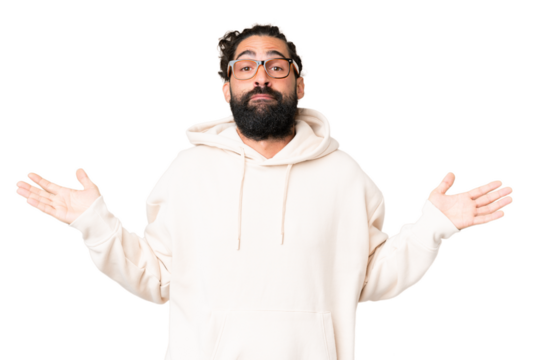 Young man with beard over isolated chroma key background having doubts while raising hands