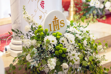 Flower decorations for the first Holy Communion with the inscription IHS, holy sacraments, Christianity