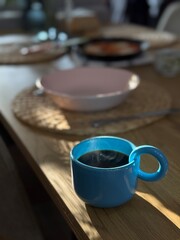 Black coffee on a wooden table with a blue cup. Batch brew, alternative. Specialty coffee. 