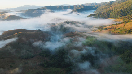 Landscape view of the fog flowing on hills at dawn by drone