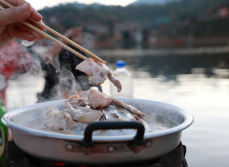 Left hand holds chopsticks take the pork ( marinated until tender) and lard or fatty pork  place it...