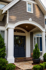 Obraz premium Elegant Home Exterior: A Stunning Architectural Design with a Charming Porch and Blue Door