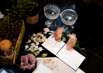 Wedding invitation postcard with floral decorations and wine glasses