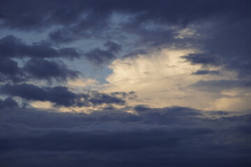 après l'orage le beau temps, nuage d'orage se dissipe pour laisser entrevoir la lumière du couché de soleil sur les nuages.