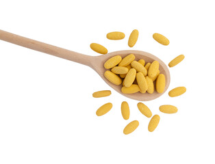 pills in wooden spoon isolated