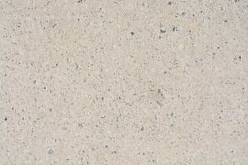 A flat, light gray concrete surface with a fine texture and small inclusions