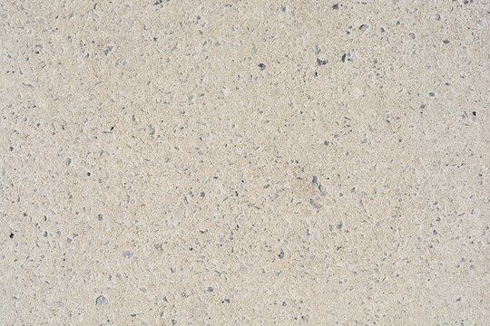 A flat, light gray concrete surface with a fine texture and small inclusions