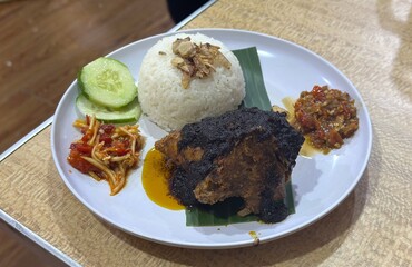 The bold flavors of Ayam Bumbu Madura, perfectly paired with steamed rice and a tangy Sambal Mangga – a delicious Indonesian feast. Serpong, Indonesia - February 2, 2025, food, meat, steak, beef, meal