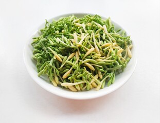 High angle view of uncooked papaya flower vegetables in a white plate on a white background. 