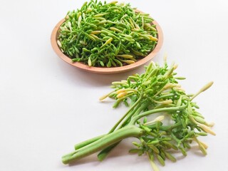 Bunch of papaya flower vegetables in a wooden plate on a white background. 