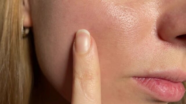 Close-Up of a Woman Examining Her Firm, Radiant Face, Highlighting Smooth Skin and Youthful Glow, Focusing on Skin Care, Anti-Aging, and Natural Beauty in a Self-Care Routine for Healthy and Rejuvenat