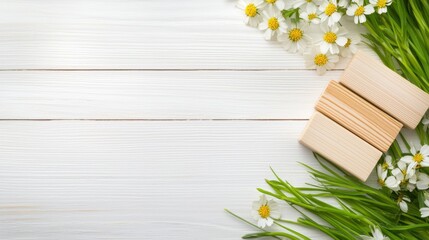 Obraz premium Wooden alphabet blocks surrounded by fresh spring flowers and blades of grass, arranged creatively on a white wooden table.