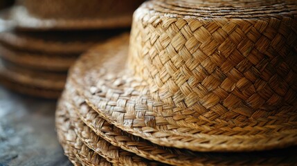 Fototapeta premium Textured surface of woven straw hats stacked on table, showcasing their intricate design and natural color. Perfect for summer fashion or outdoor activities