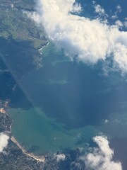 Fototapeta premium Aerial views form a plane looking through the clouds onto dramatic coastline. 