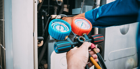 Technician is checking air conditioner refrigerant leak.