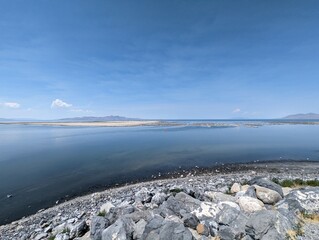 Scenic View of the Great Salt Lake with Rocky Shoreline and Clear Blue Sky.