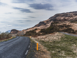 Route sinueuse à travers les paysages montagneux d’Islande