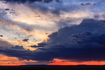 The sky is filled with clouds and the sun is setting
