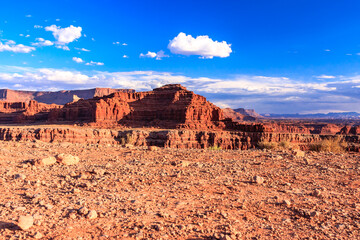 A desert landscape with a large rock formation in the background