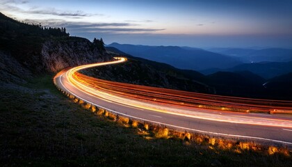A long exposure photograph of a winding road with car light trails