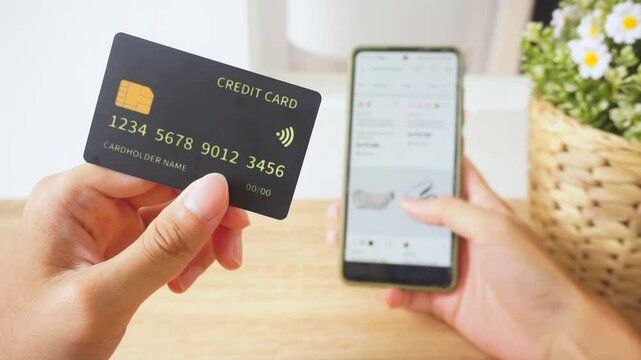 Pov first person holding black mockup credit card for online shop on smartphone at home	
