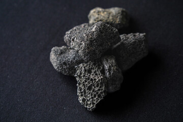 Black volcanic stone on black background.