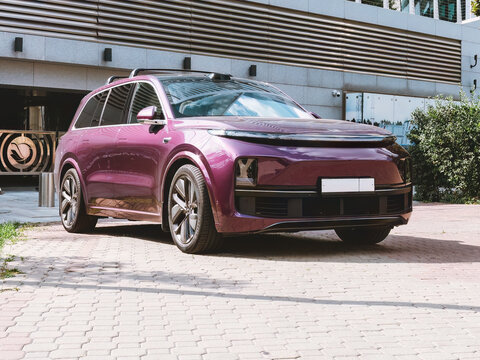 Purple full-size crossover Li L9 lixiang from Chinese manufacturer Li Auto parked against office building background