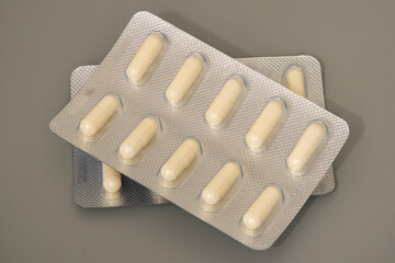 Capsules arranged on blister packs lying on a gray surface