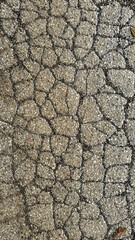 Close-up of cracked, weathered asphalt road texture symbolizing urban decay, infrastructure problems, and environmental challenges