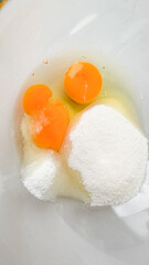 Egg yolks and sugar in a bowl, symbolizing baking preparations for holiday desserts, fostering culinary creativity