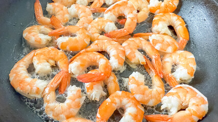 Pan-fried shrimp sizzling in a skillet, perfect for seafood enthusiasts or celebrating National Shrimp Day, emphasizing fresh cooking