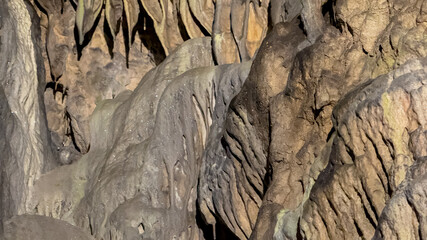 Intricate limestone formations inside a dimly lit cave represent geological wonders, ideal for concepts of exploration and natural beauty