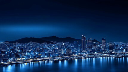 Obraz premium Night city skyline, harbor reflection, mountain backdrop, urban landscape