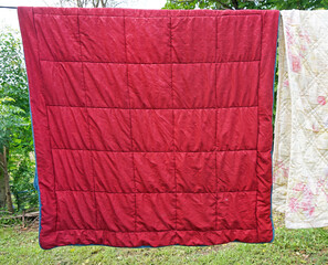 red blanket hanging on a clothesline
