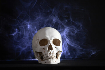 Human skull on a black background in smoke.