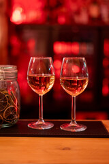 Wine glasses with white wine in the luxury bar, nightlife in night club, red light