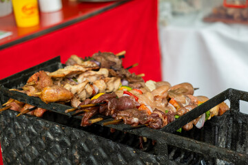 skewers with meat, vegetables and charcoal grilled chicken in the streets of the city of la paz bolivia - street food concept